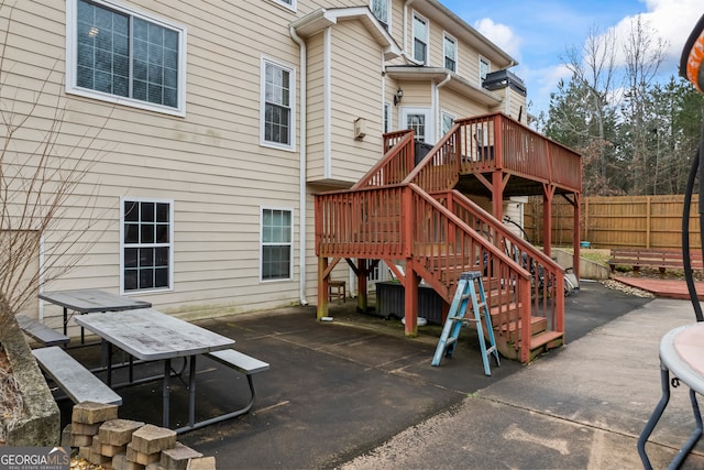 rear view of property featuring a wooden deck and a patio