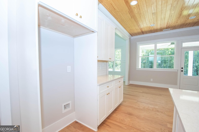 kitchen with wood ceiling, plenty of natural light, light hardwood / wood-style floors, white cabinets, and decorative backsplash