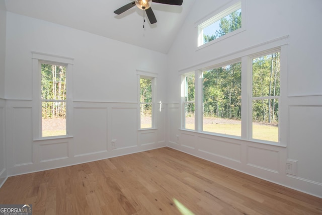 empty room featuring ceiling fan, lofted ceiling, and light hardwood / wood-style flooring