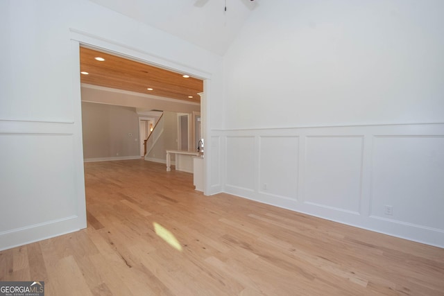 spare room featuring light hardwood / wood-style flooring, ceiling fan, and vaulted ceiling