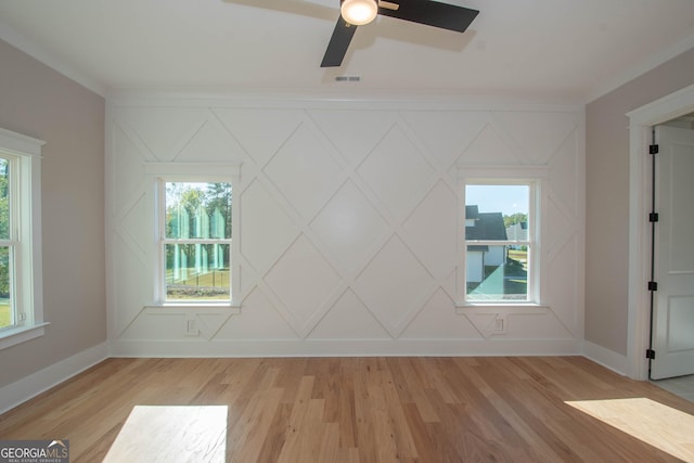 spare room with crown molding, light hardwood / wood-style flooring, ceiling fan, and plenty of natural light