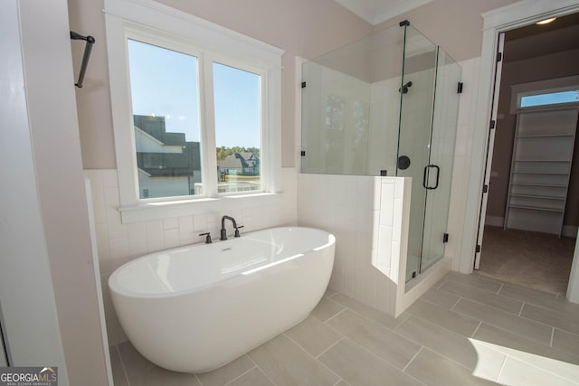 bathroom featuring tile patterned flooring, shower with separate bathtub, and tile walls