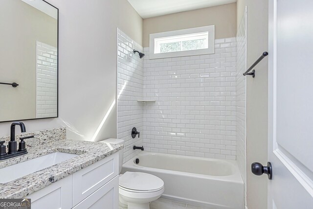 full bathroom featuring tiled shower / bath, vanity, and toilet