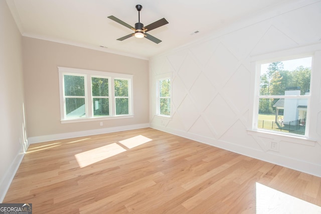 empty room with ornamental molding, a healthy amount of sunlight, and light wood-type flooring