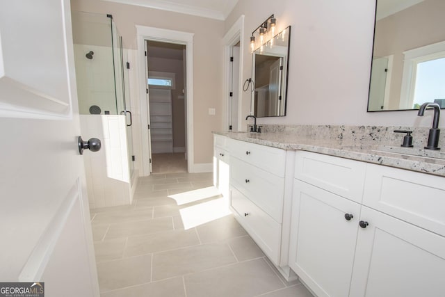 bathroom featuring walk in shower, tile patterned floors, crown molding, and vanity