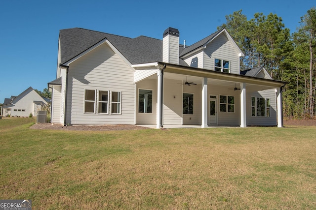 rear view of property with ceiling fan, a patio area, and a lawn