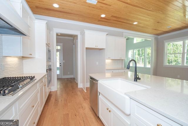 kitchen with sink, premium range hood, tasteful backsplash, white cabinets, and wooden ceiling