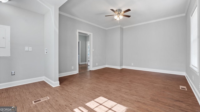 spare room featuring hardwood / wood-style flooring, ornamental molding, ceiling fan, and electric panel