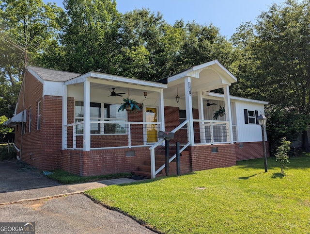 view of front of house with a ceiling fan, a front lawn, and brick siding