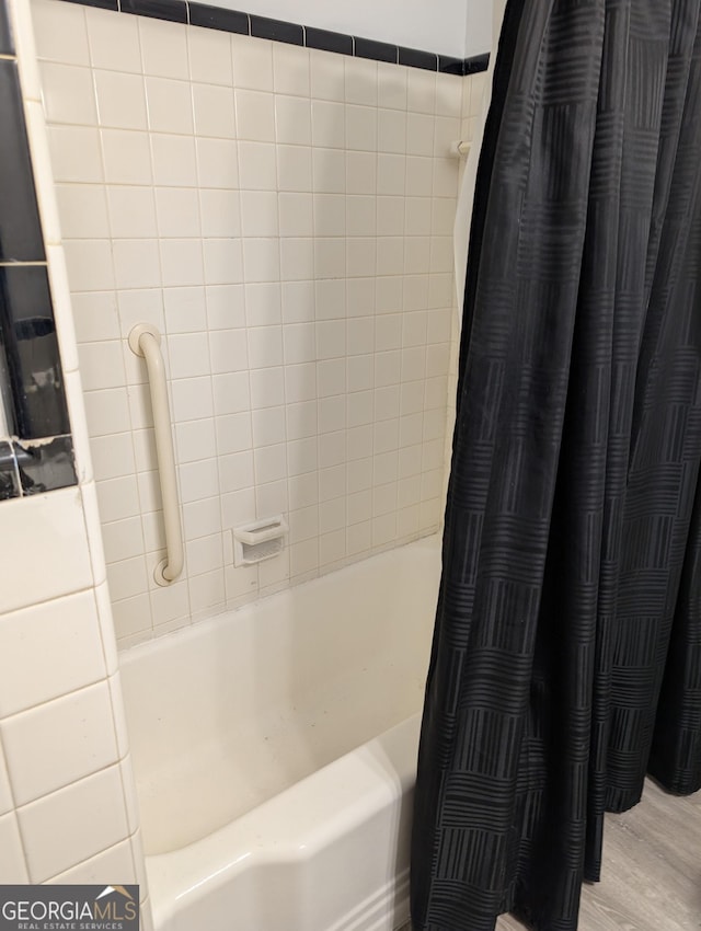 bathroom with shower / tub combo and wood finished floors