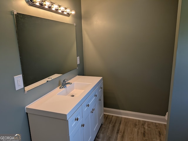bathroom featuring wood finished floors, vanity, and baseboards