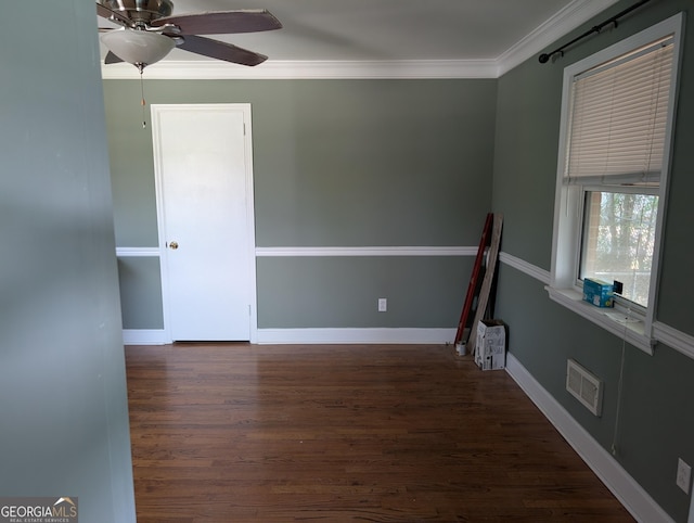 spare room with a ceiling fan, wood finished floors, ornamental molding, and baseboards