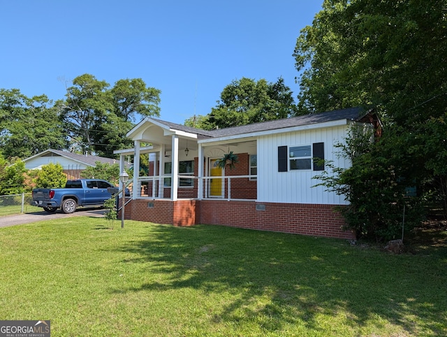 view of front of house with board and batten siding, brick siding, driveway, and crawl space