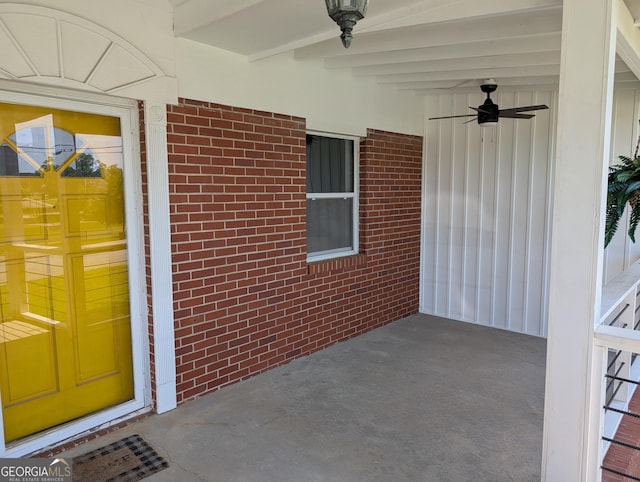 doorway to property with a ceiling fan and brick siding