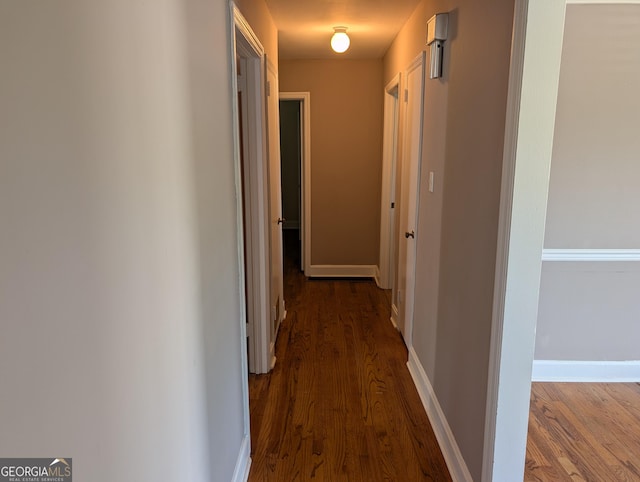 corridor with wood finished floors and baseboards
