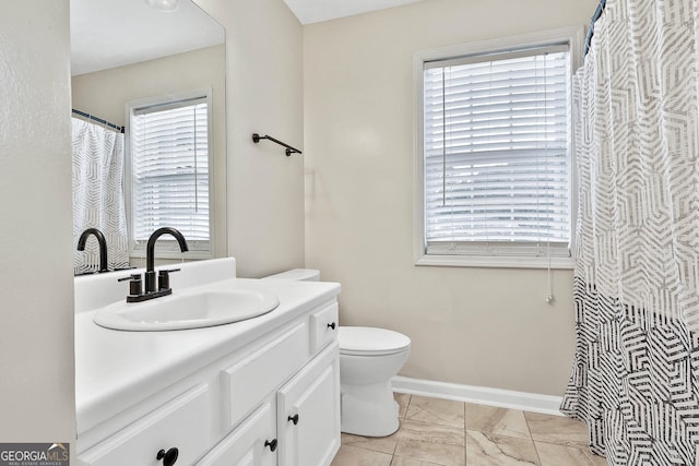 bathroom featuring vanity, a healthy amount of sunlight, and toilet