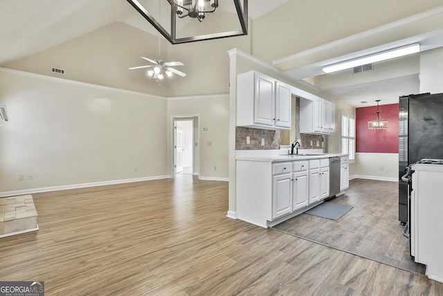 kitchen featuring high vaulted ceiling, light wood-type flooring, stainless steel dishwasher, white cabinets, and backsplash