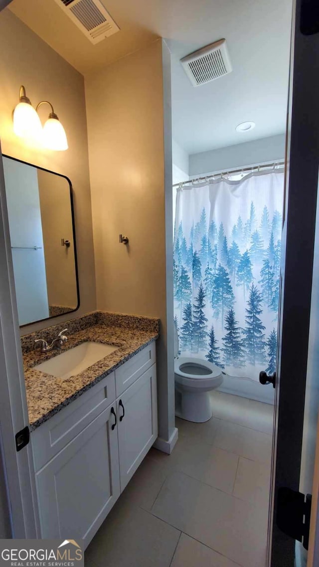 bathroom with vanity, toilet, and tile patterned flooring