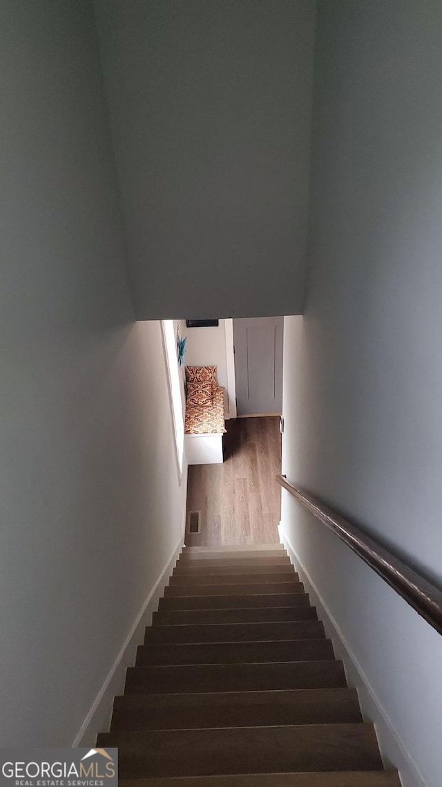 staircase with hardwood / wood-style floors