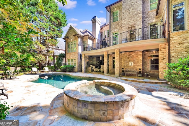 view of swimming pool with a patio and an in ground hot tub