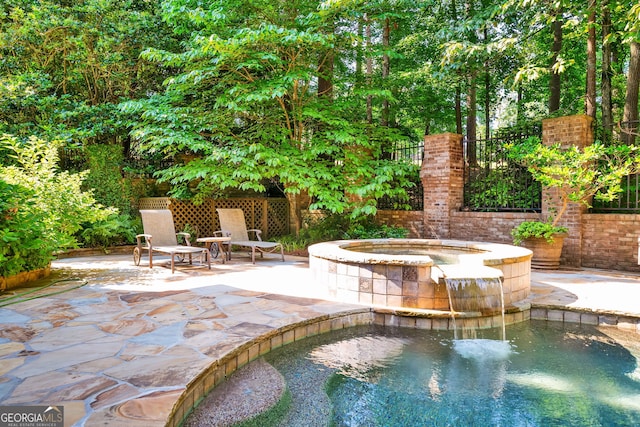 view of swimming pool with a patio area and an in ground hot tub