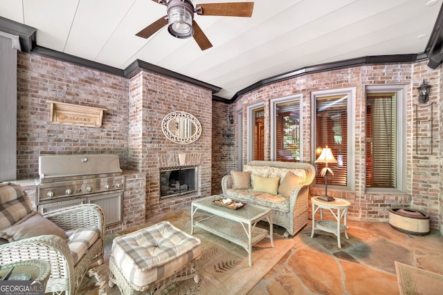 living room featuring ceiling fan, brick wall, and a fireplace