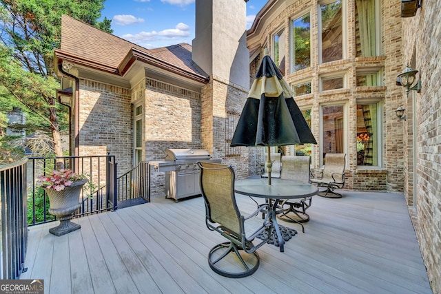 wooden deck featuring a grill