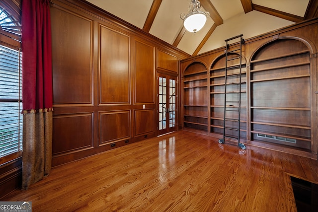 unfurnished office featuring high vaulted ceiling, hardwood / wood-style floors, beam ceiling, and wood walls