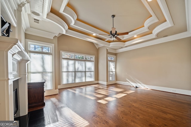 unfurnished living room with dark hardwood / wood-style floors, ornamental molding, a raised ceiling, and ceiling fan