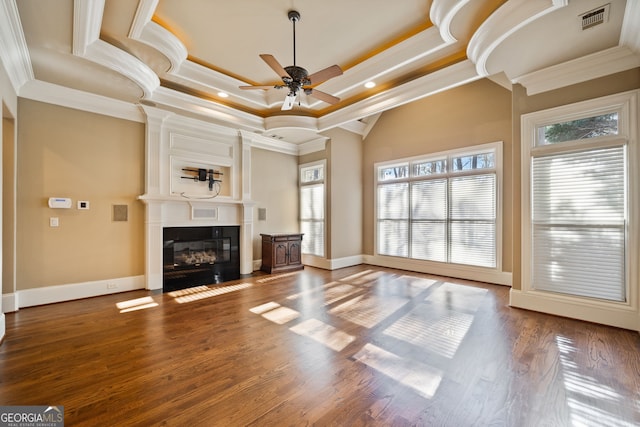 unfurnished living room featuring crown molding, dark hardwood / wood-style flooring, a fireplace, and a raised ceiling