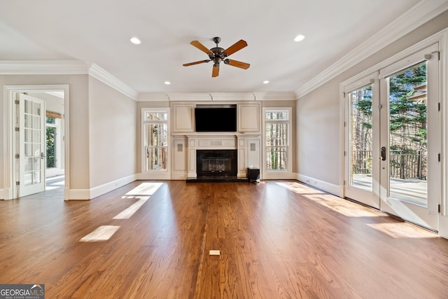 unfurnished living room with crown molding, ceiling fan, light wood-type flooring, and french doors