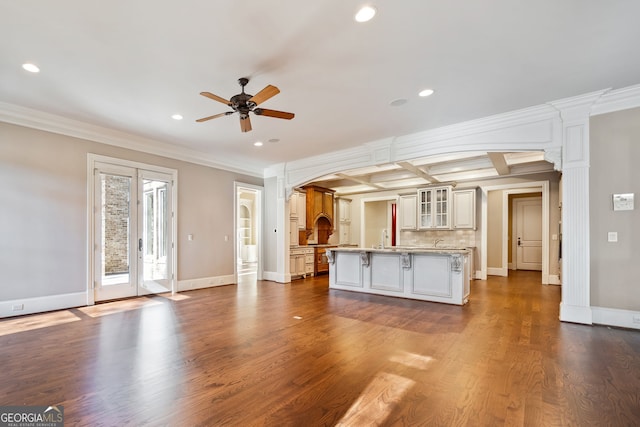 unfurnished living room featuring ceiling fan, ornamental molding, coffered ceiling, and beam ceiling