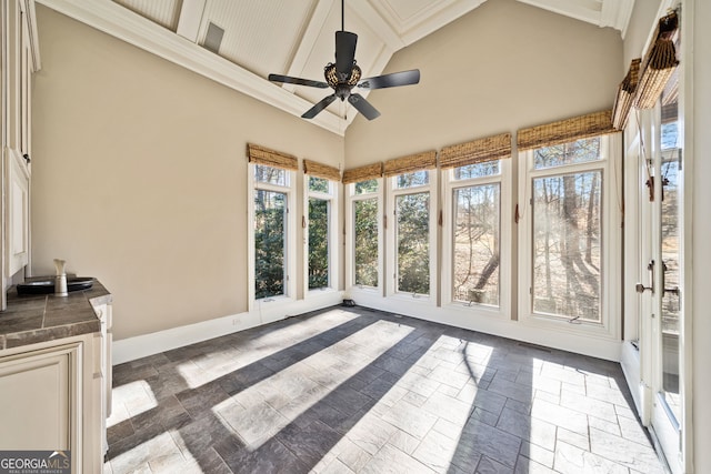 sunroom with ceiling fan and beamed ceiling