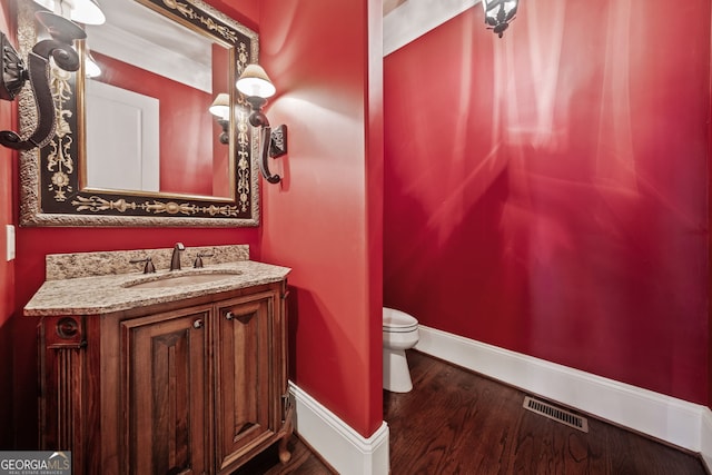 bathroom with vanity, wood-type flooring, and toilet