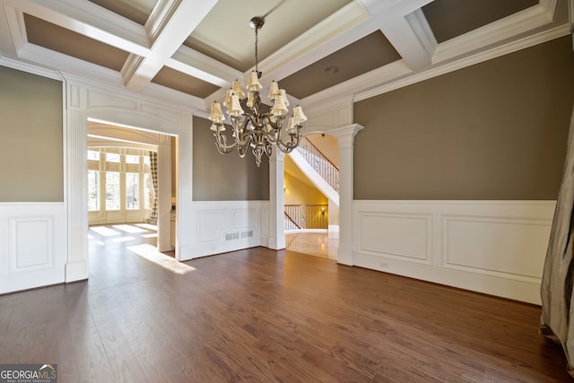 unfurnished dining area featuring dark hardwood / wood-style floors, a chandelier, ornamental molding, coffered ceiling, and beam ceiling