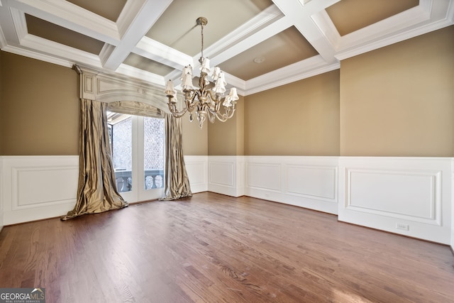 spare room featuring beamed ceiling, crown molding, coffered ceiling, and an inviting chandelier