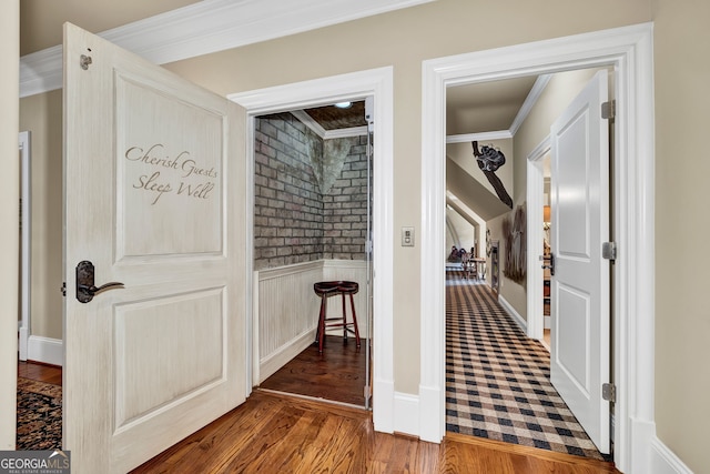 corridor with ornamental molding and dark hardwood / wood-style floors