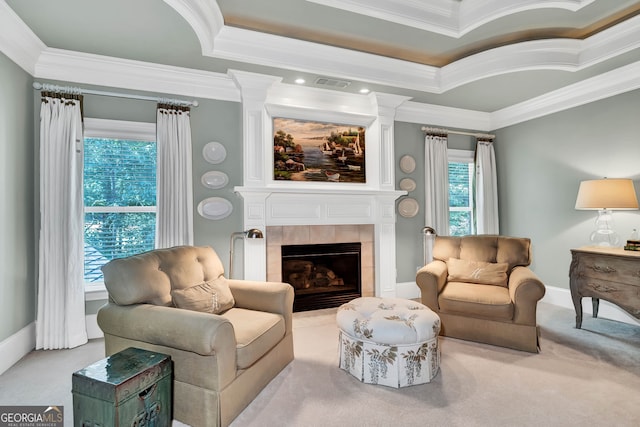 living room featuring a tiled fireplace, crown molding, a raised ceiling, and light carpet