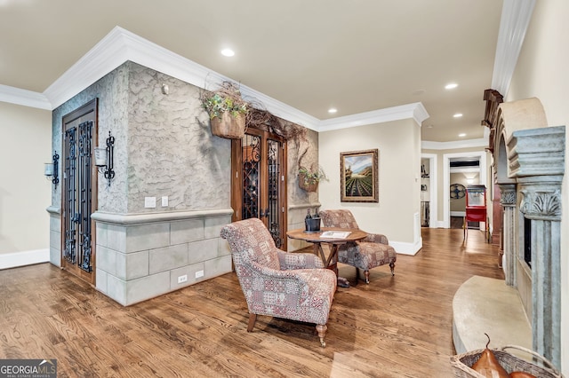 living area featuring hardwood / wood-style flooring and ornamental molding