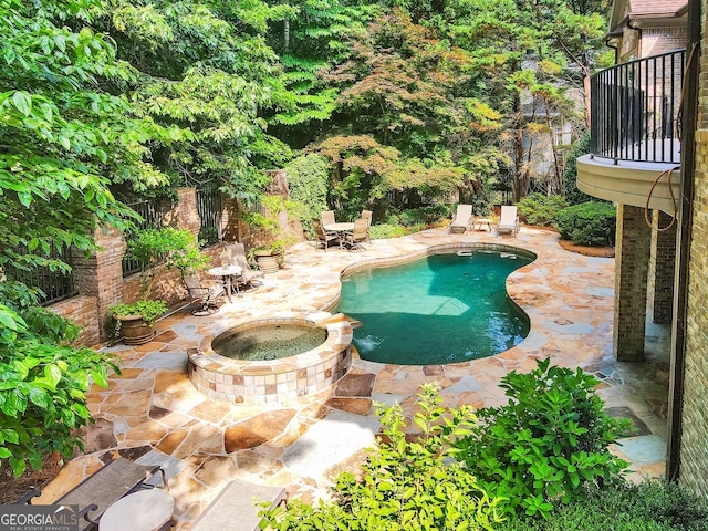 view of swimming pool featuring an in ground hot tub and a patio area