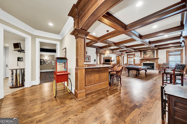 interior space with hardwood / wood-style floors, beam ceiling, coffered ceiling, decorative light fixtures, and ornate columns