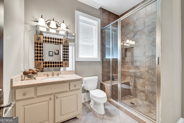 bathroom featuring tile patterned flooring, vanity, a shower with shower door, and toilet