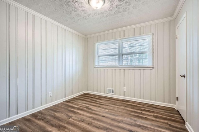 empty room with ornamental molding, dark hardwood / wood-style floors, and a textured ceiling