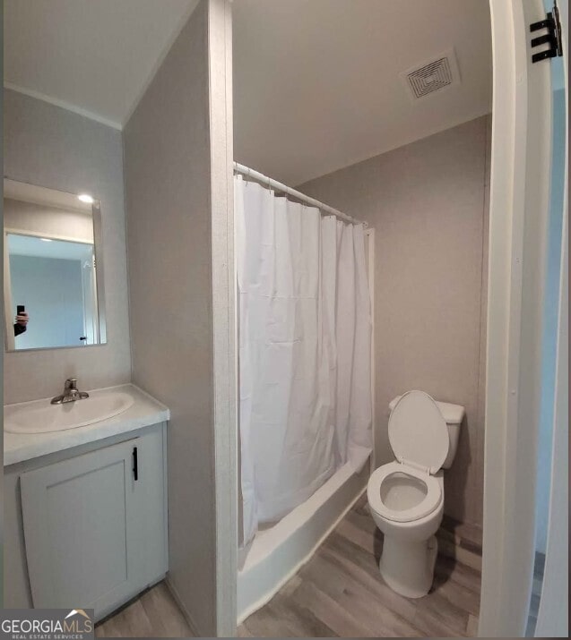 bathroom featuring vanity, hardwood / wood-style floors, a shower with curtain, and toilet