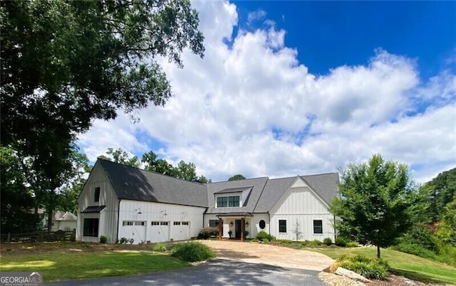 modern inspired farmhouse with a garage and a front lawn