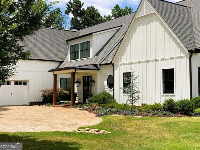 rear view of property with a garage and a lawn