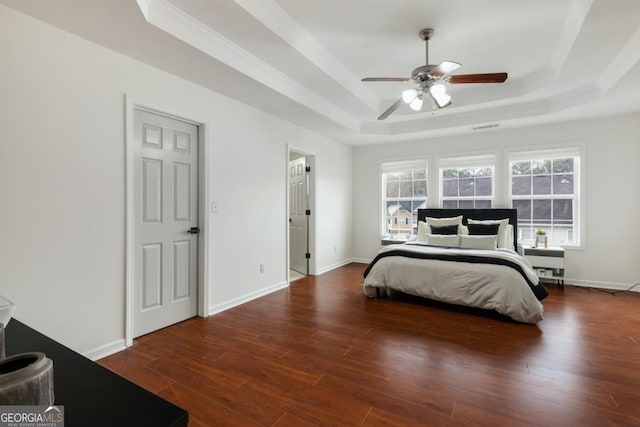 bedroom with a tray ceiling, dark hardwood / wood-style floors, and ceiling fan