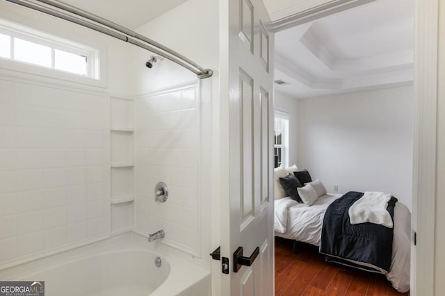 bathroom featuring hardwood / wood-style flooring, bathing tub / shower combination, and plenty of natural light