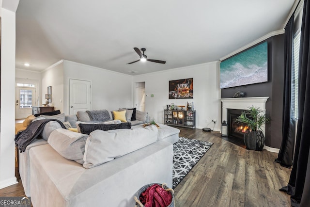 living room with ornamental molding, dark hardwood / wood-style floors, and ceiling fan