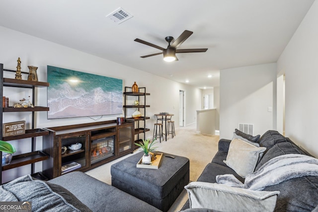 living room with carpet floors, visible vents, and a ceiling fan